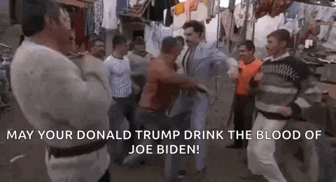 a group of men are dancing in a slum area and a man is holding a sword .