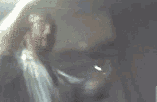 a blurry picture of a man with his arms outstretched in a room