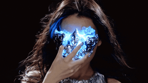 a woman covering her face with a glowing object