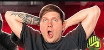 a man with a tattoo on his arm is holding his hands behind his head and making a funny face .
