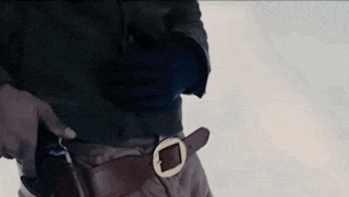 a close up of a person holding a gun in their pocket .
