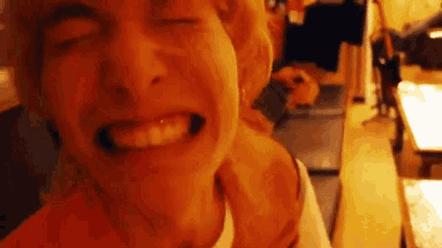 a close up of a person making a funny face with their eyes closed and their mouth open .