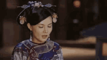 a woman in a blue dress with chinese writing on her face