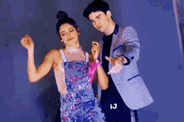 a man and a woman are standing next to each other and dancing together .