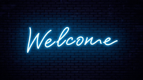 a neon sign that says welcome is on a brick wall .