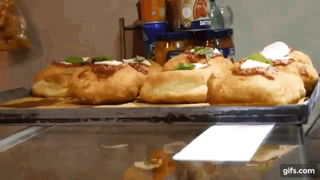 a bunch of pizzas are sitting on a tray in front of jars that say dattero