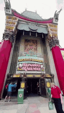 a man standing in front of a building that says runaway railway .