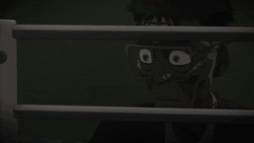 a man wearing glasses looks through a fence with his eyes wide open