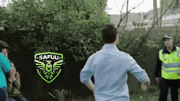 a man in a blue shirt is running in front of a police officer .