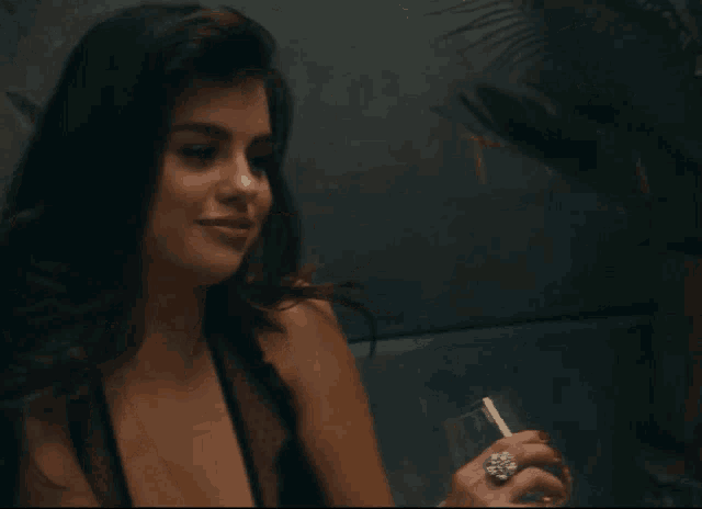 a woman smoking a cigarette and wearing a ring