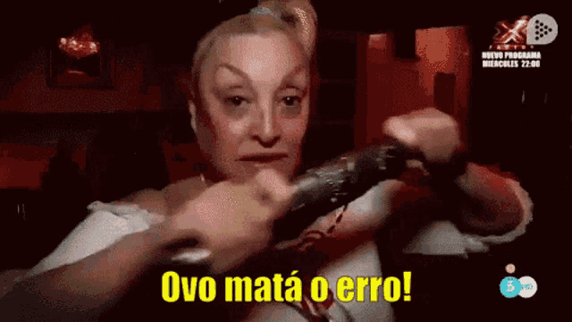 a woman is holding a microphone with the words ovo mata o error above her