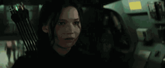 a woman is sitting in a car with a bow and arrow in her hand .