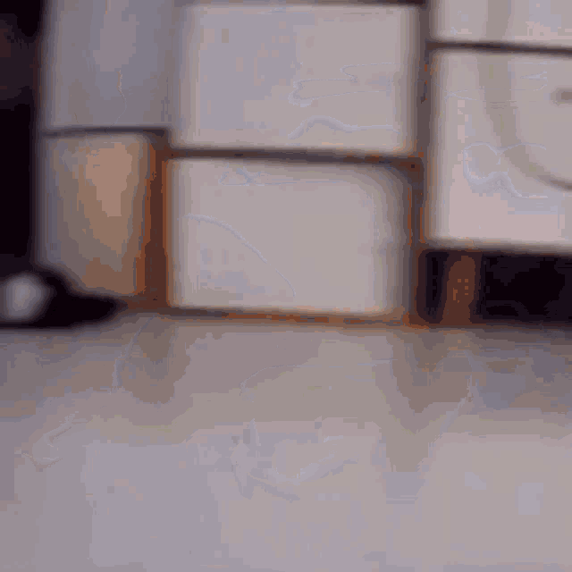 a person is standing on a white tiled floor in front of a dresser .