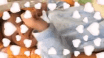 a baby laying on a bed with white hearts surrounding him