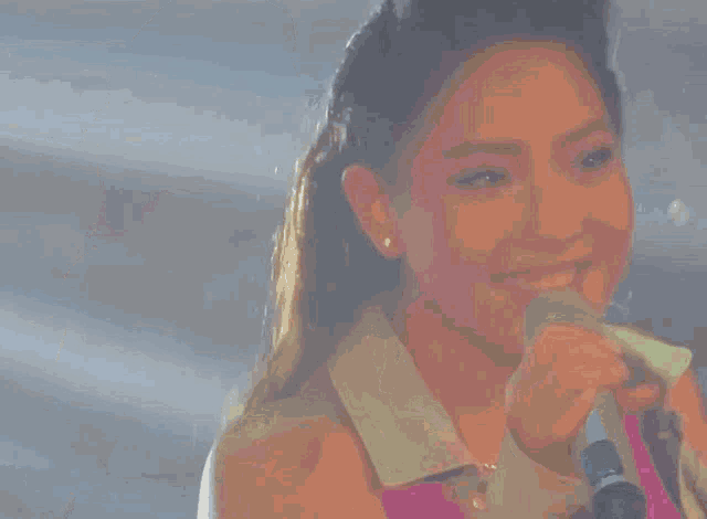 a blurry picture of a woman holding a microphone and pointing .