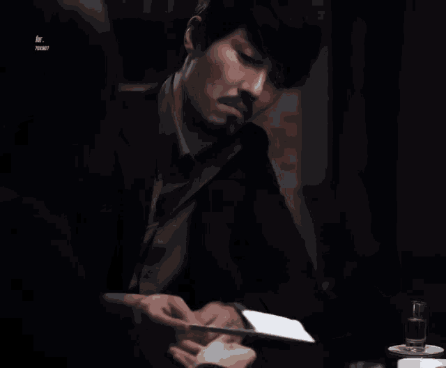 a man with a beard is reading a letter