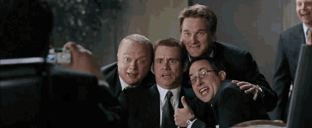 a group of men in suits are posing for a photo