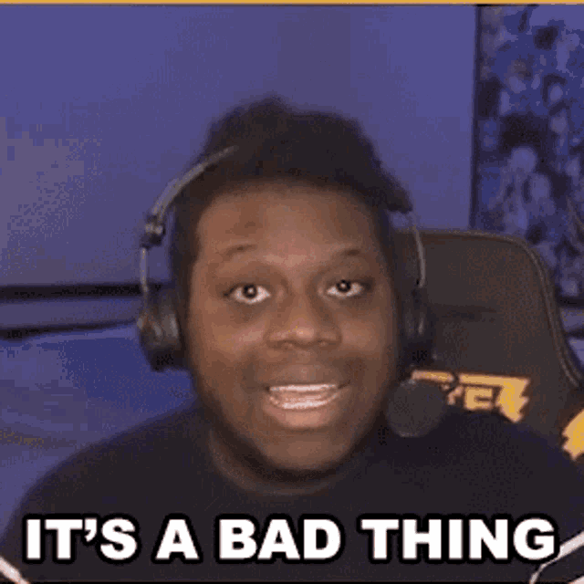 a man wearing headphones and a microphone is sitting in a chair and saying it 's a bad thing .