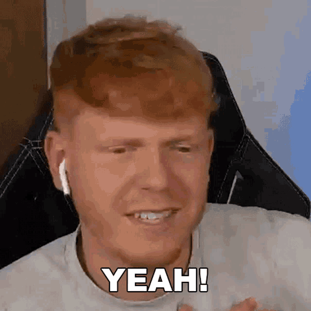 a man with red hair is wearing ear buds and saying yeah