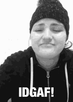 a woman wearing a beanie and a hoodie is making a funny face .