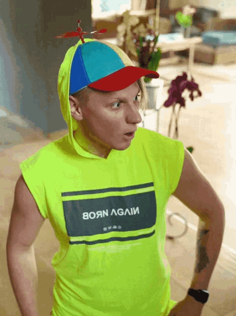 a man wearing a yellow shirt that says born again on it