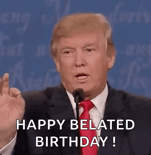 donald trump is giving a speech in front of a microphone and says happy belated birthday .