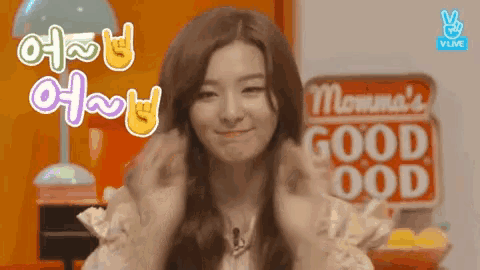 a woman is smiling in front of a sign that says good food