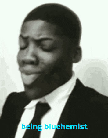 a man in a suit and tie with the words being bluchemist below him