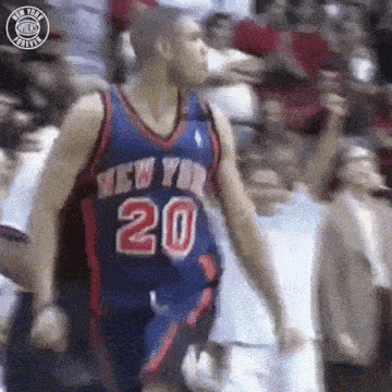 a basketball player in a new york knicks jersey is standing in front of a crowd .