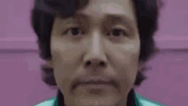 a close up of a person 's face with a pink background .