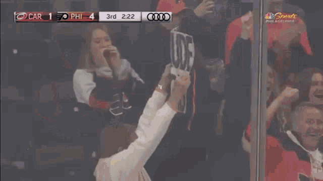 a woman holds a sign that says claude reigns