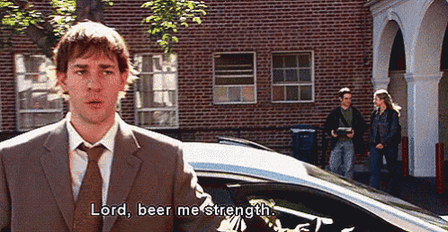 a man in a suit and tie is standing in front of a car and talking to it .