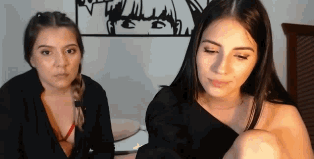 two women are sitting next to each other and looking at the camera