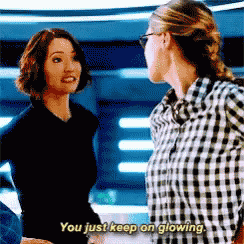 two women are standing next to each other and one of them is saying `` you just keep on glowing . ''