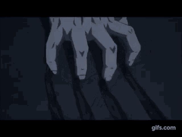 a close up of a person 's hand holding another person 's hand in a dark room .