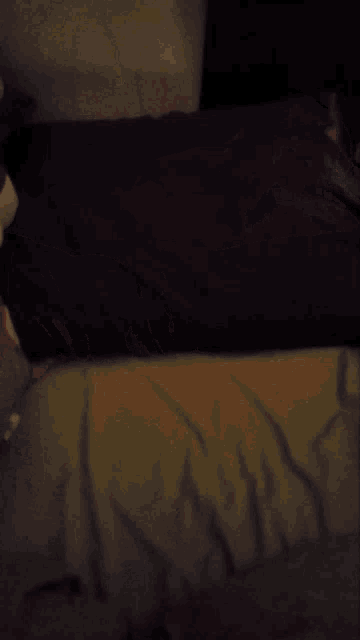 a person 's hand is laying on a bed