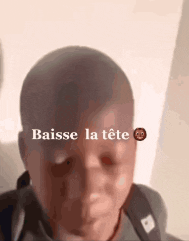 a close up of a child 's face with the words baisse la tete written above it