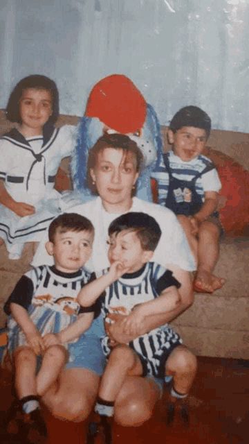 a group of children are posing for a picture with a woman in a white shirt with the number 14 on it