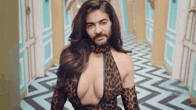 a woman with a beard is wearing a leopard print dress .
