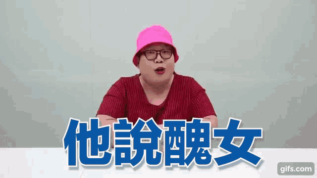 a woman wearing glasses and a pink hat is sitting at a table with chinese writing on it .