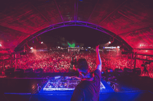 a dj playing music in front of a crowd with a sign that says ' x ' on it