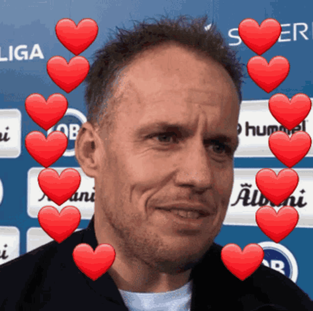 a man is surrounded by red hearts in front of a sign that says " liga "