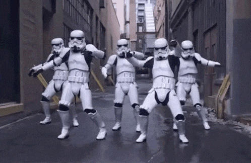 a group of stormtroopers are dancing in an alleyway in a city .
