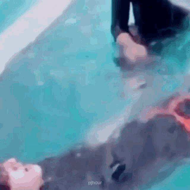 a person is swimming in a pool with their feet in it .