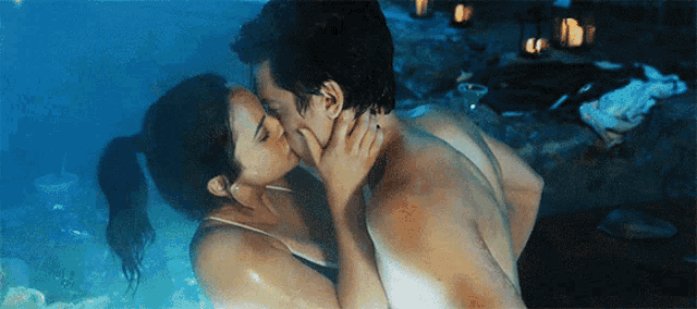 a man and a woman are kissing in a hot tub
