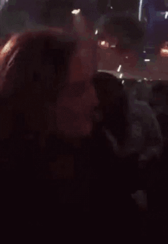 a woman is dancing in a club and holding a cup in her hand