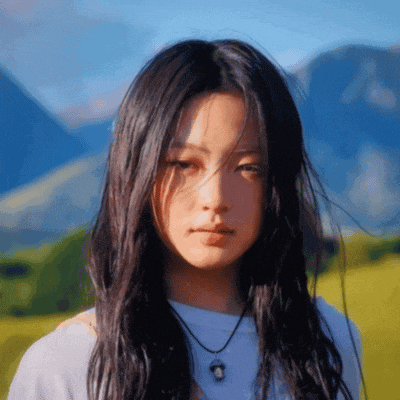 a young woman with long dark hair is wearing a white shirt and a necklace