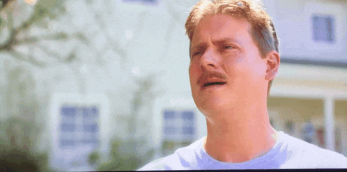 a man with a mustache is making a sad face