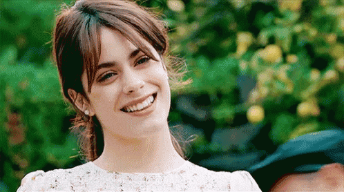 a woman in a white dress is smiling for the camera