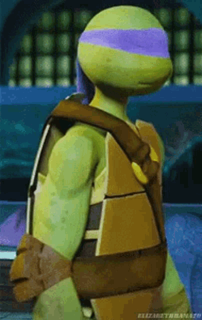 a teenage mutant ninja turtle with a purple headband is standing in a dark room .